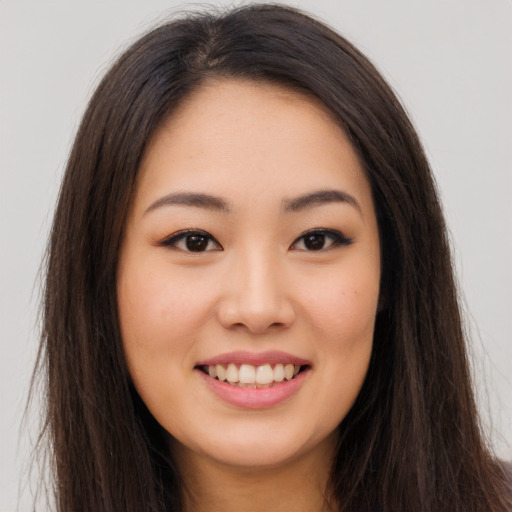Joyful asian young-adult female with long  brown hair and brown eyes