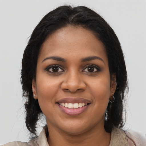 Joyful black young-adult female with long  brown hair and brown eyes