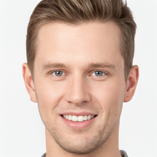 Joyful white young-adult male with short  brown hair and grey eyes