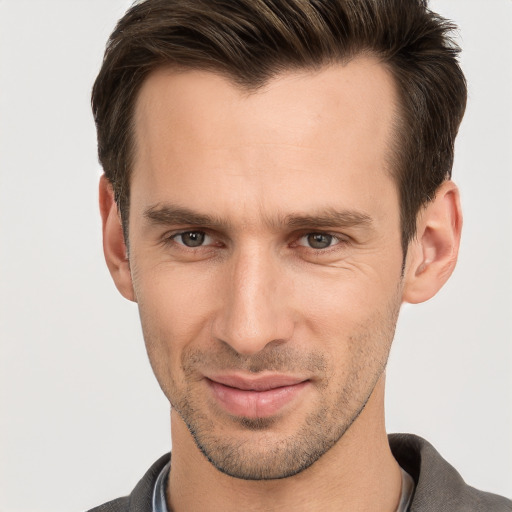 Joyful white young-adult male with short  brown hair and grey eyes