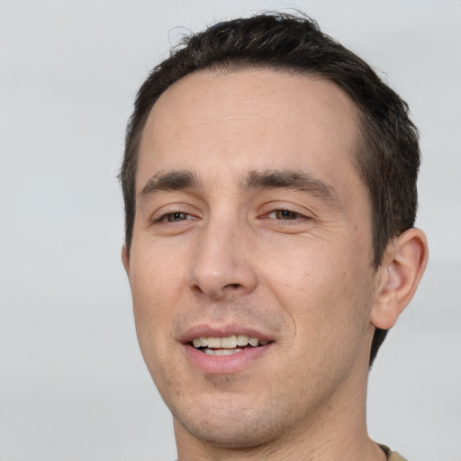 Joyful white young-adult male with short  black hair and brown eyes