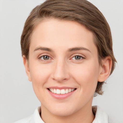 Joyful white young-adult female with short  brown hair and green eyes