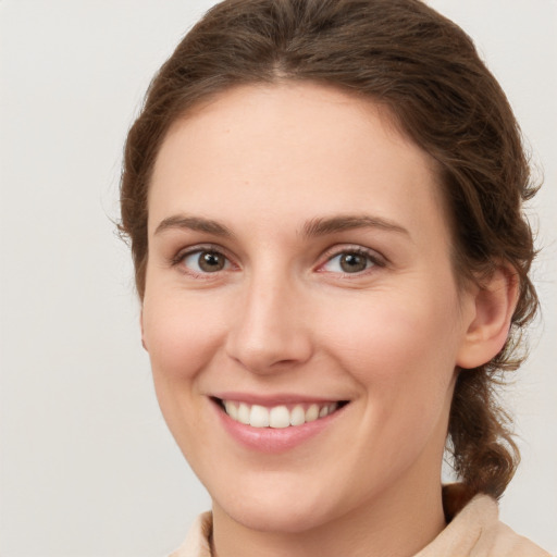 Joyful white young-adult female with medium  brown hair and green eyes