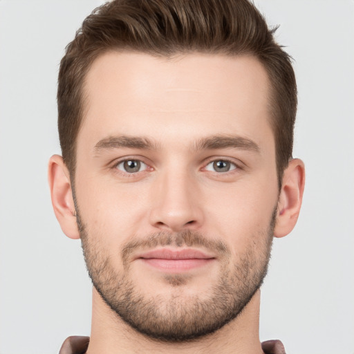 Joyful white young-adult male with short  brown hair and grey eyes