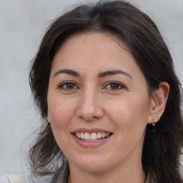 Joyful white adult female with long  brown hair and brown eyes