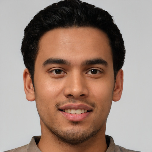 Joyful latino young-adult male with short  black hair and brown eyes