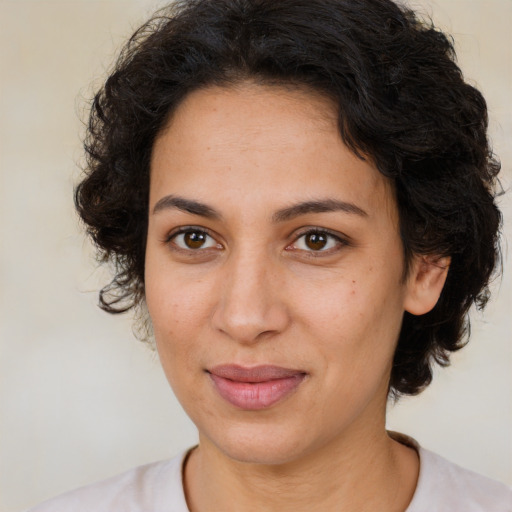 Joyful latino adult female with medium  brown hair and brown eyes