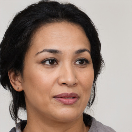 Joyful latino adult female with medium  brown hair and brown eyes