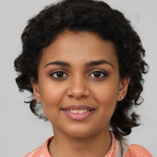 Joyful black young-adult female with medium  brown hair and brown eyes