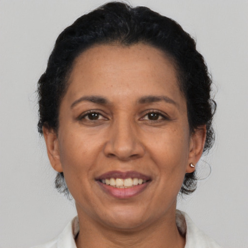 Joyful latino adult female with short  black hair and brown eyes