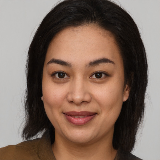 Joyful latino young-adult female with medium  brown hair and brown eyes