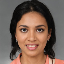 Joyful latino young-adult female with medium  brown hair and brown eyes