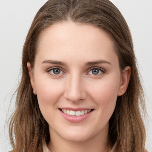 Joyful white young-adult female with long  brown hair and grey eyes