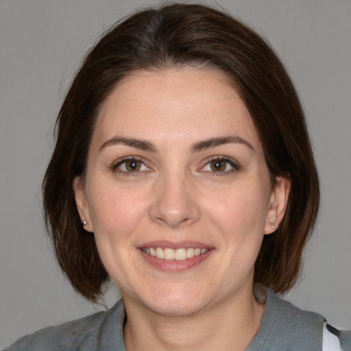 Joyful white adult female with medium  brown hair and brown eyes