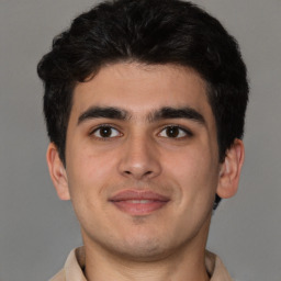 Joyful latino young-adult male with short  brown hair and brown eyes