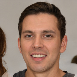 Joyful white young-adult male with short  brown hair and brown eyes