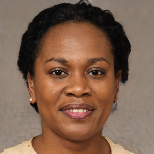 Joyful black adult female with short  brown hair and brown eyes