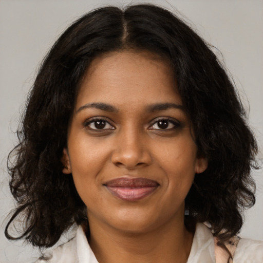 Joyful black young-adult female with medium  brown hair and brown eyes