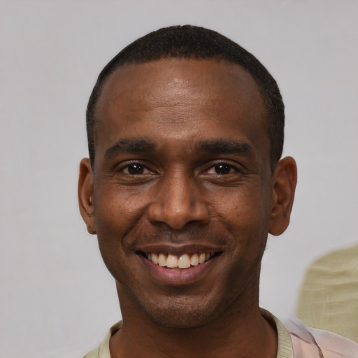 Joyful black young-adult male with short  black hair and brown eyes