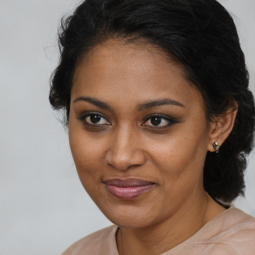 Joyful black young-adult female with long  brown hair and brown eyes