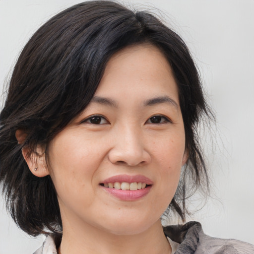 Joyful asian young-adult female with medium  brown hair and brown eyes