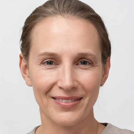 Joyful white adult female with medium  brown hair and grey eyes