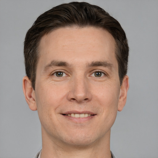 Joyful white adult male with short  brown hair and brown eyes