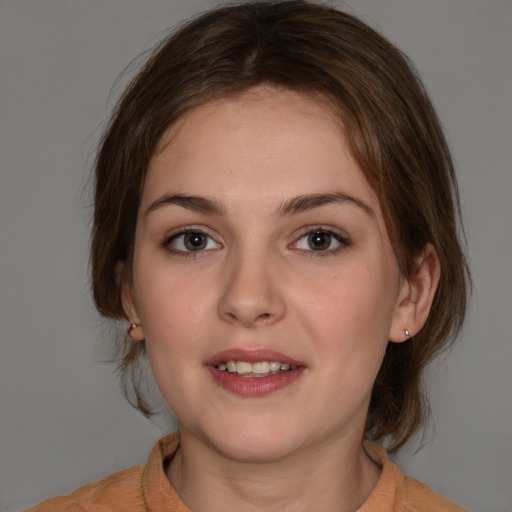 Joyful white young-adult female with medium  brown hair and grey eyes