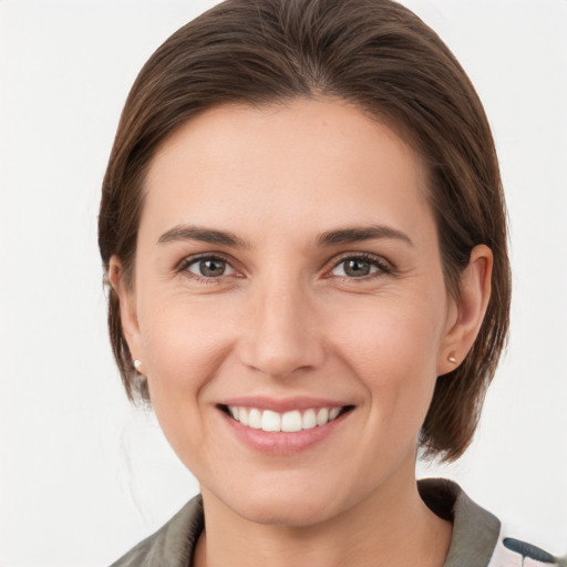 Joyful white young-adult female with medium  brown hair and grey eyes