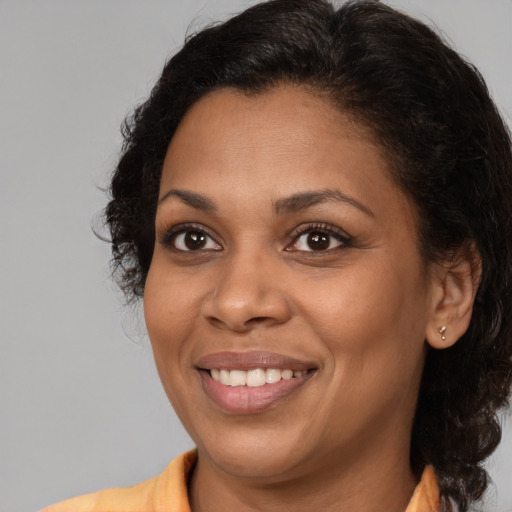 Joyful black young-adult female with medium  brown hair and brown eyes
