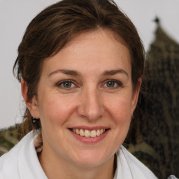 Joyful white adult female with medium  brown hair and grey eyes