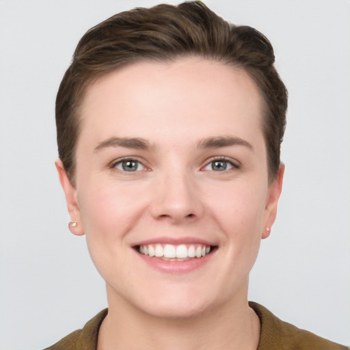 Joyful white young-adult female with short  brown hair and grey eyes