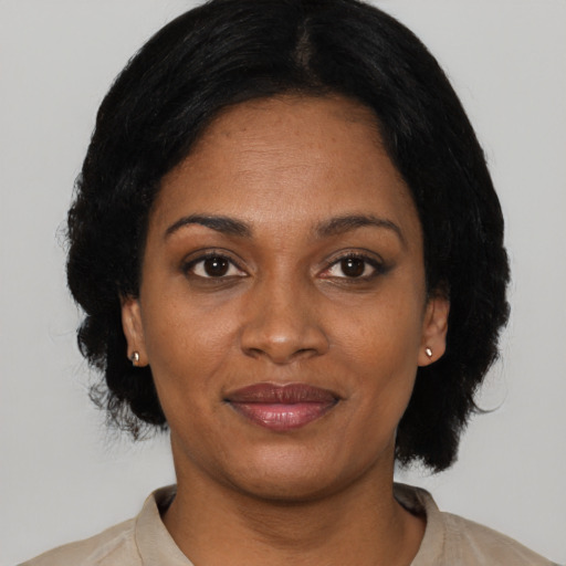 Joyful black adult female with medium  black hair and brown eyes