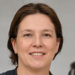 Joyful white adult female with medium  brown hair and grey eyes