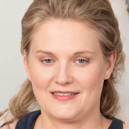 Joyful white young-adult female with medium  brown hair and blue eyes