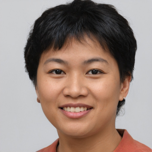 Joyful asian young-adult female with short  brown hair and brown eyes