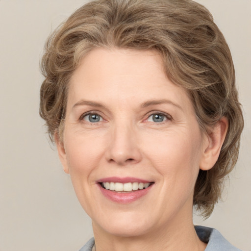 Joyful white adult female with medium  brown hair and grey eyes