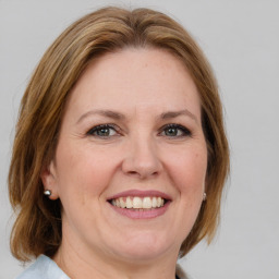 Joyful white adult female with medium  brown hair and grey eyes