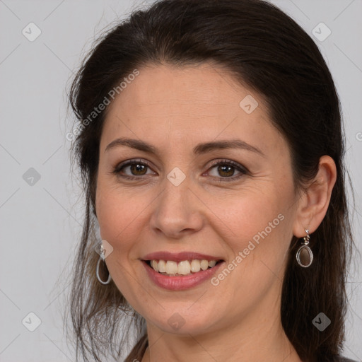 Joyful white adult female with long  brown hair and brown eyes