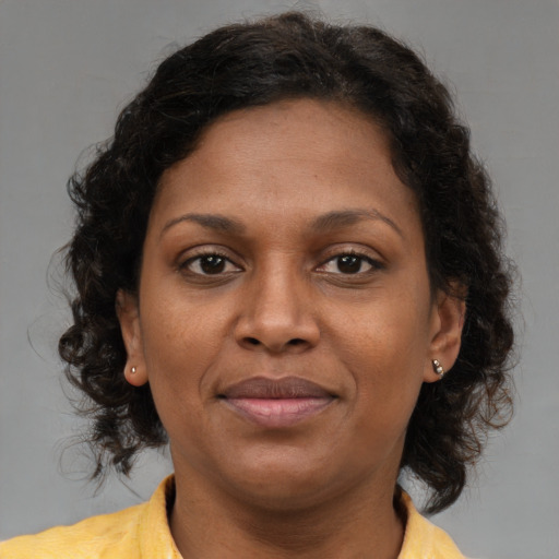 Joyful black adult female with medium  brown hair and brown eyes