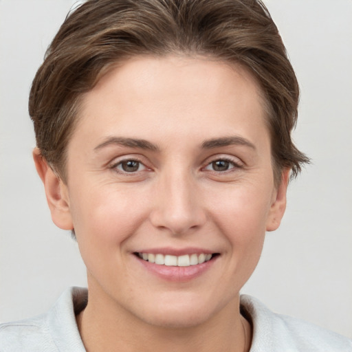 Joyful white young-adult female with short  brown hair and grey eyes