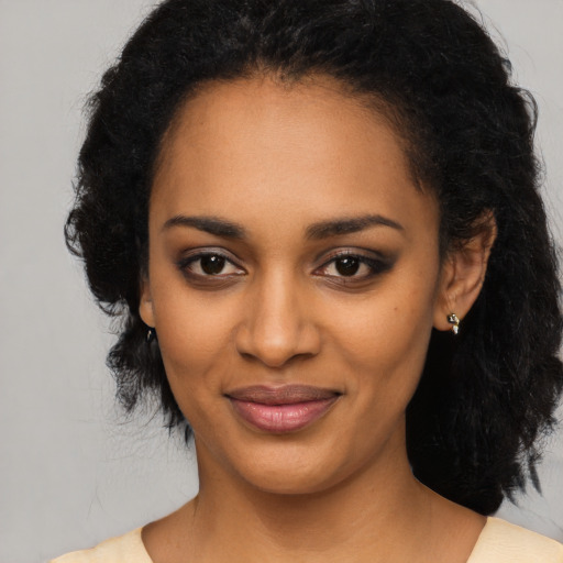 Joyful black young-adult female with medium  black hair and brown eyes