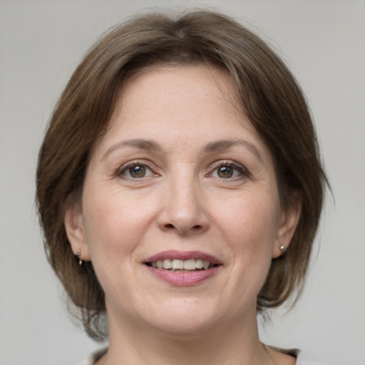 Joyful white adult female with medium  brown hair and grey eyes