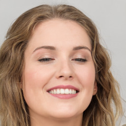 Joyful white young-adult female with long  brown hair and green eyes