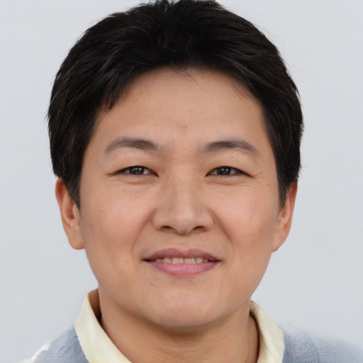 Joyful asian adult male with short  brown hair and brown eyes