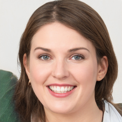 Joyful white young-adult female with medium  brown hair and grey eyes