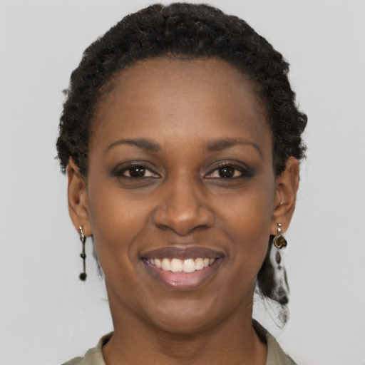 Joyful black young-adult female with short  brown hair and brown eyes