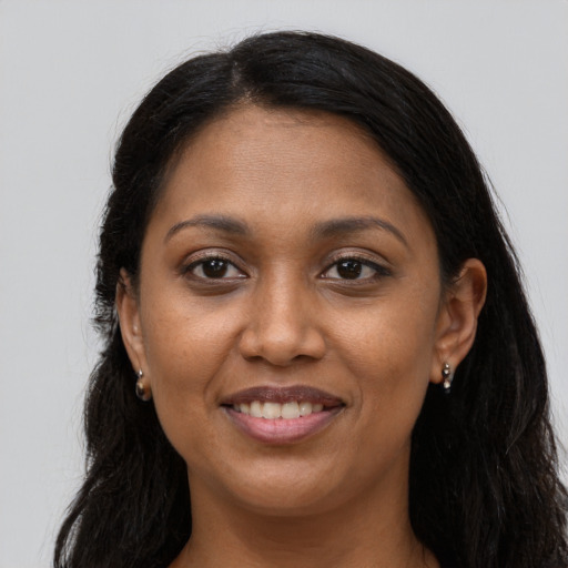 Joyful black young-adult female with long  brown hair and brown eyes