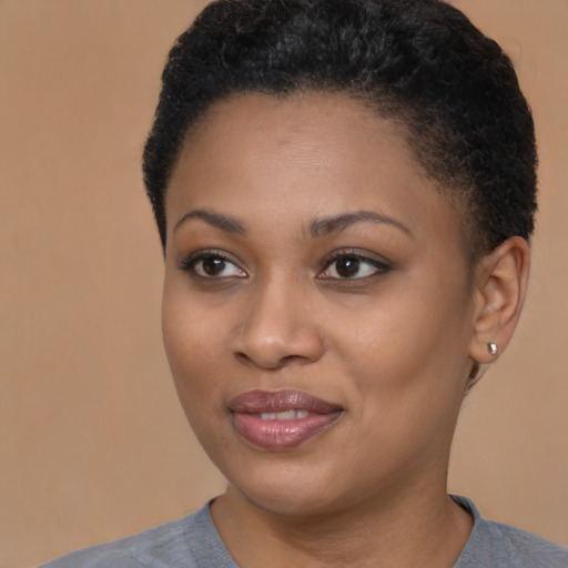Joyful black young-adult female with short  black hair and brown eyes