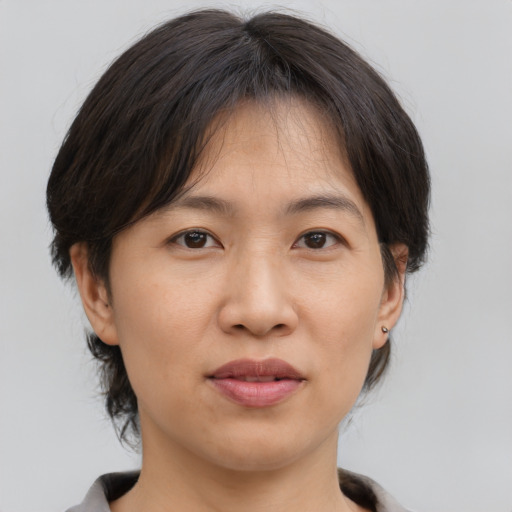 Joyful asian adult female with medium  brown hair and brown eyes